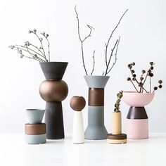 several vases with flowers in them sitting on a table next to eachother