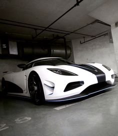 a white and black sports car parked in a parking garage