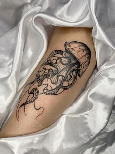 a tattoo on the leg of a woman with an octopus and flowers in her hair