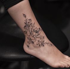 a woman's foot with a flower tattoo on it