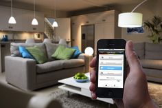 a person holding up a smart phone in front of a living room with couches