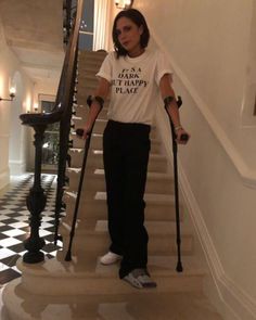 a woman with crutches is walking down the stairs while holding two canes