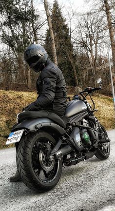 a man riding on the back of a black motorcycle