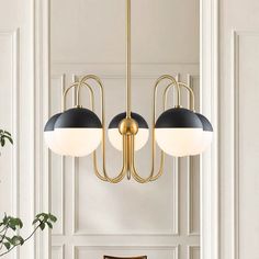 three lights hanging from the ceiling in a room with white walls and wood flooring