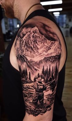 a man with a mountain scene tattoo on his arm