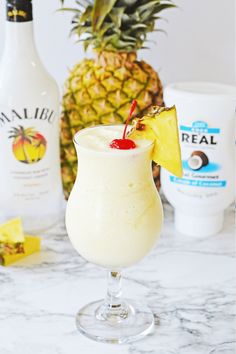 a pineapple drink is garnished with a cherry