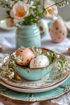 two eggs are in a bowl on a table with flowers and vases behind it