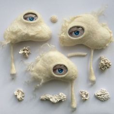 three stuffed animals with blue eyes and white hair on them, all made out of wool