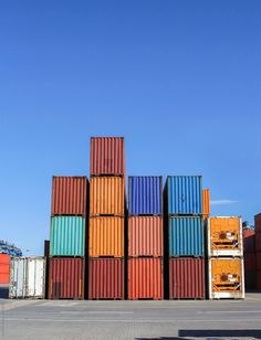 several colorful containers stacked on top of each other in front of a blue sky by paul smith for stockstations