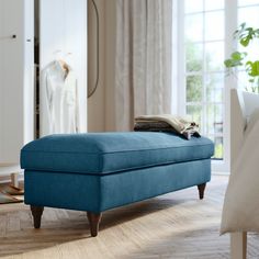 a grey ottoman sitting on top of a hard wood floor