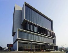 a large building with many windows on the side of it's face in front of a parking lot