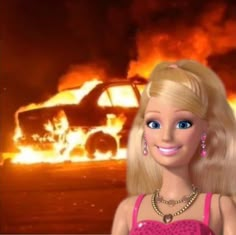 a barbie doll standing in front of a burning car