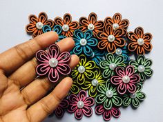 a hand holding a bunch of small colorful flowers