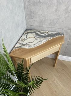 a wooden bench sitting next to a plant on top of a hard wood flooring