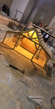 an unfinished house is shown in the process of being built, with tools and materials scattered around it