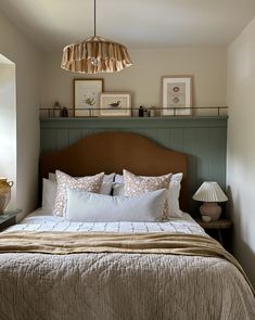 a bedroom with a bed, lamps and pictures on the wall above it's headboard