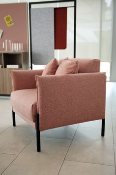 a pink chair sitting on top of a tiled floor