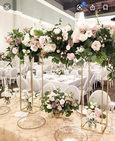 the tables are set with white and pink flowers in vases on top of them