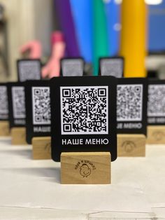 there are four wooden plaques with qr - code on them sitting on a table