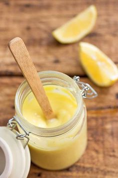 a jar filled with lemon custard on top of a wooden table