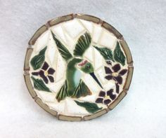 a ceramic bird sitting on top of a white table