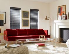 a living room filled with furniture and a fire place in front of a window covered in blinds