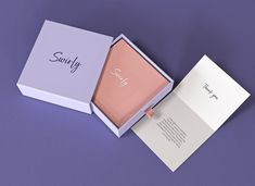 an open box with the word sunny on it sitting on a purple surface next to a note pad