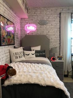 a bed room with a neatly made bed and a neon sign above the headboard