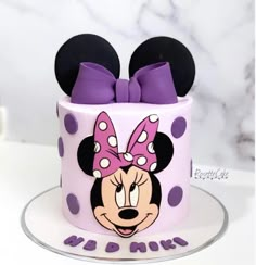 a minnie mouse cake with purple bows and polka dots