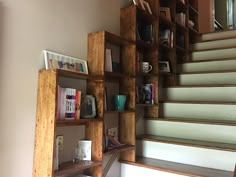 some bookshelves sitting on the side of a set of stairs