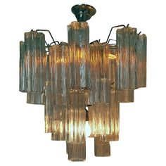 a chandelier made out of glass tubes with lights hanging from the top and bottom