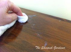 a person wiping off some white stuff on a wooden table