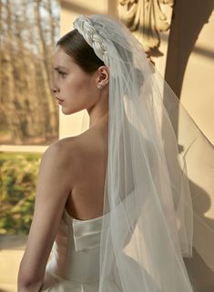 a woman in a wedding dress with a veil on her head