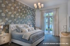 a bedroom with floral wallpaper and white bedding, chandelier, nightstands, lamps, and mirror