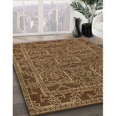 a brown rug with an intricate design on the floor in front of a large window