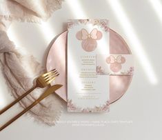 a pink and gold plate with a menu on it next to a fork and napkin