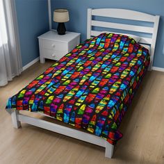 a bed in a room with blue walls and wooden floors, has a multicolored bedspread on it