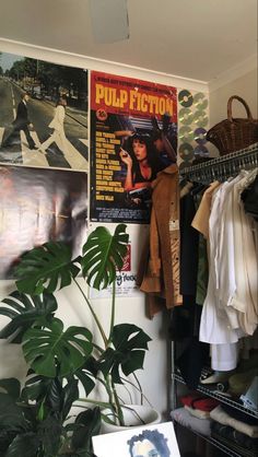 a room with posters on the wall and a plant