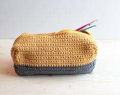 a crocheted purse with pencils sticking out of it