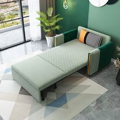 a living room with a green couch and white rug in front of a large window