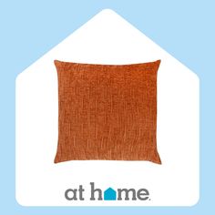 an orange pillow sitting on top of a blue and white house with the words at home above it