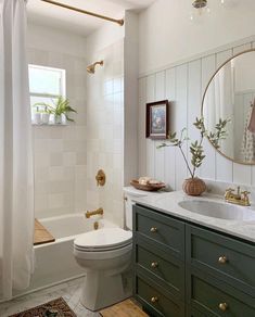 a bathroom with green cabinets and a white toilet