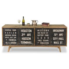 a wooden cabinet with three different signs on the front and two wine glasses sitting on top