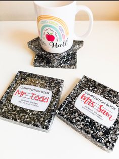 three tea bags and a coffee mug sitting on a white counter top with black speckles