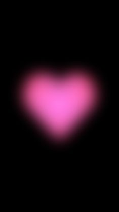 a blurry image of a pink heart in the dark