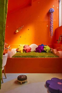 an orange room with purple and green decorations on the bed, pink walls and floor