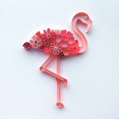 a pink flamingo with flowers on its head and tail is standing in front of a white background