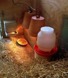 an animal pen with hay, food and other items on the floor next to it