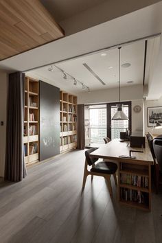 a dining room table with chairs and bookshelves