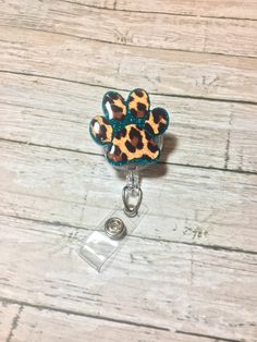 a cell phone charm with a leopard print paw on it's front and bottom